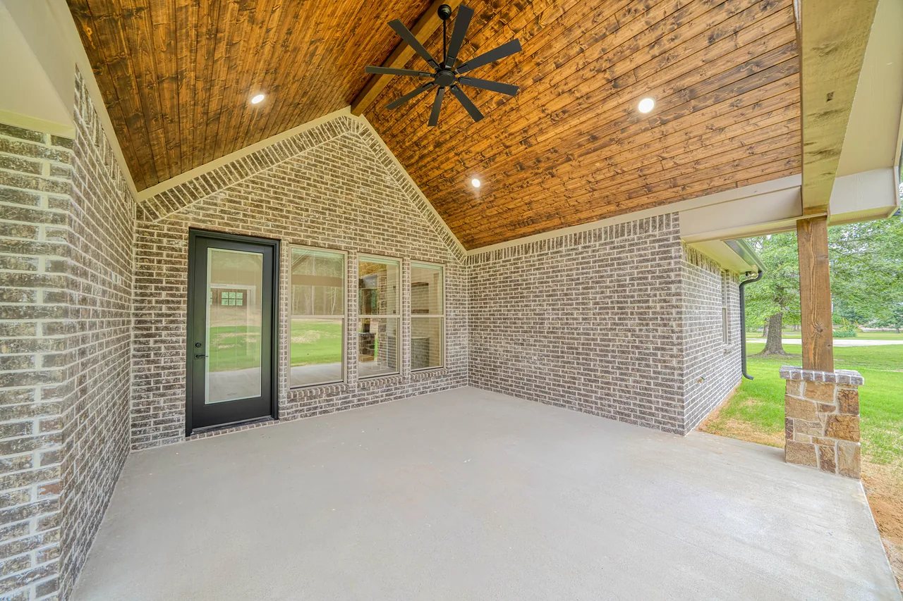 Covered brick patio with wood ceiling, Homes by Noble