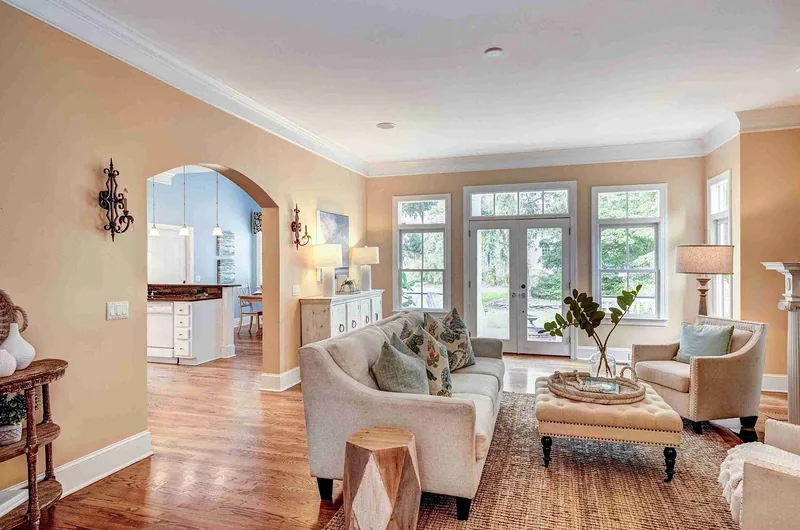 Living room with an arched doorway, French doors and hardwood floors